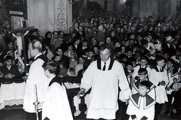 Stanisław Psiuk prowadzący procesję ministrantów przez wypełnioną po brzegi bazylikę.