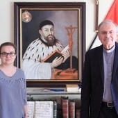 Amelia Waszkiewicz i ks. Grzegorz Rafiński prezentują portret o. Rowedera, który w oryginale znaleźć można w oliwskiej świątyni