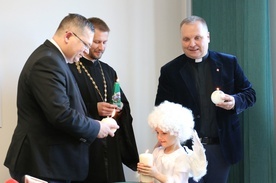 Od świecy aniołka, w którego wcieliła się Julka, swoje wigilijne świece zapalili (od lewej) ks. Wojciech Rudkowski, ks. Paweł Sidoruk i ks. Robert Kowalski