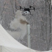 Dron bada próbki powietrza nad dymiącym kominem