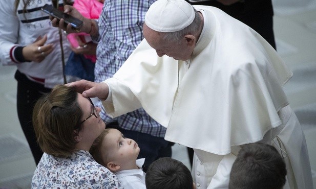 Papież Franciszek podczas audiencji błogosławi rodzinę