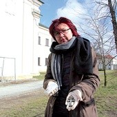 ▲	Archeolog Monika Kamińska z wydobytym z grobu srebrnym krzyżykiem.