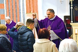Biskup Włodarczyk podczas posypywania głów wiernych popiołem.