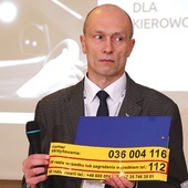 ▲	Marcin Kruszyński, zastępca dyrektora Biura Komunikacji i Promocji PKP PLK, prezentuje nalepkę. 