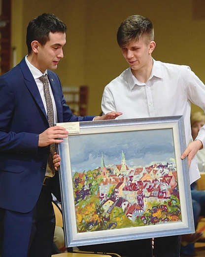▲	Wśród darów znalazł się obraz przedstawiający panoramę Olsztyna. Wylicytował go europoseł prof. Karol Karski.