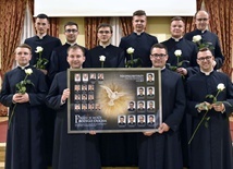 Grupowe zdjęcie z tablo, które na pamiątkę nowi kapłani zostawili w seminarium.