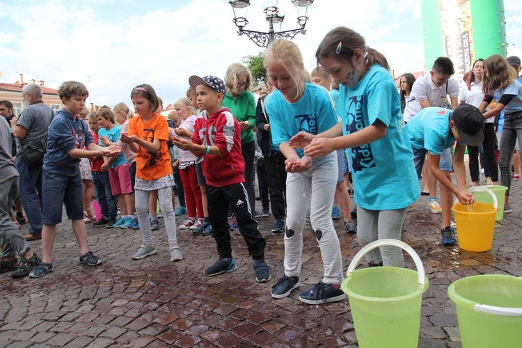 Dzieci podczas próby bicia rekordu w przenoszeniu wody rękami.