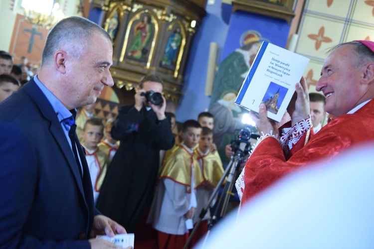 Dr Marek Smoła wręcza w darze ołtarza dwa tomy monografii parafii w Biegonicach.