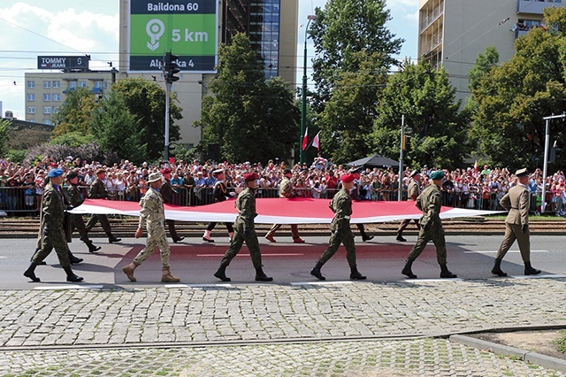 Przemarsz wojsk rozpoczęli żołnierze niosący flagę Polski.