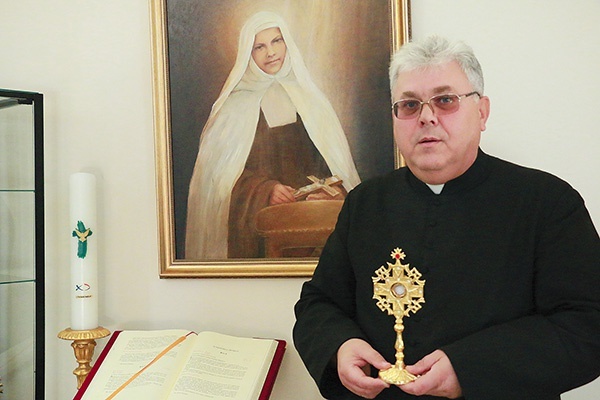 Ks. proboszcz Robert Brzozowski pokazuje relikwiarz  i obraz Miriam umieszczony w kościele.