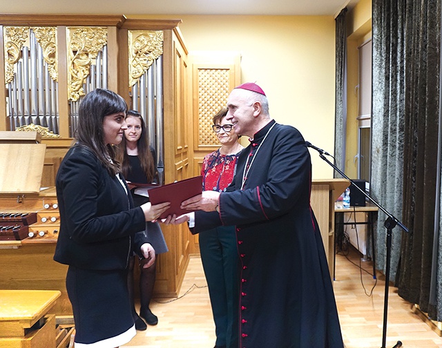 ▲	Biskup wręcza dyplom Weronice Mężyńskiej z parafii Ducha Świętego w Gliwicach-Ostropie, jednej z absolwentek gliwickiego SMK. 