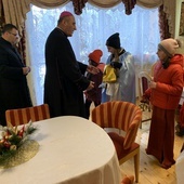 Biskup wraz z kolędnikami na słupieckiej plebanii.