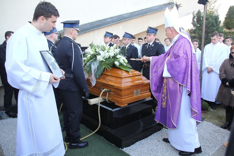 Bp Józef Guzdek przy trumnie z ciałem ks. Marka Kręciocha składanej do grobu przy kościele parafialnym.