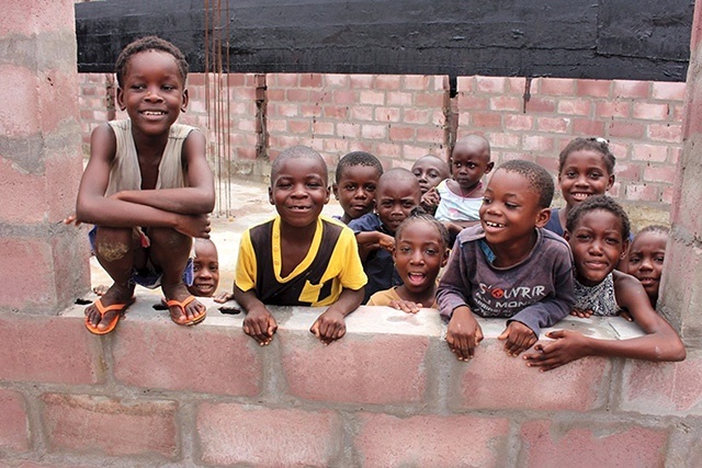 Dzieci przy jednej ze ścian budowanej szkoły.
