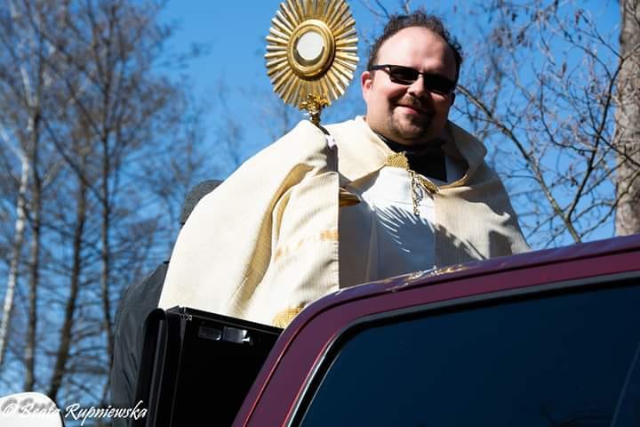 Radziwiłłowiski wikariusz z auta błogosławił wiernych Najświętszym Sakramentem.