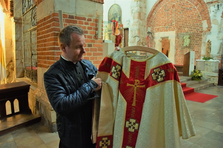 Ks. Piotr Nowak pokazuje replikę ornatu, w którym kard. Wojtyła celebrował Mszę św. w Tumie w 1967 roku.