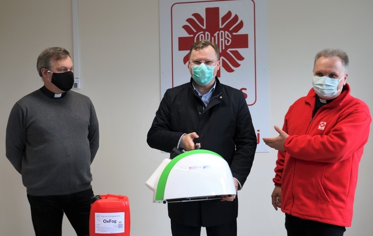 W siedzibie diecezjalnej Caritas ks. Szymon Pikus (z lewej) i ks. Robert Kowalski, dyrektor Caritas Diecezji Radomskiej, przekazali fumigator Julianowi Wróblowi, dyrektorowi przysuskiego szpitala.