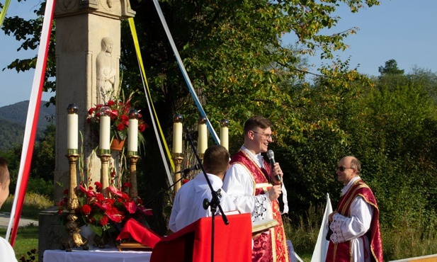 Ks. Marcin Hałas przy ołtarzu ustawionym przed XIX-wiecznym krzyżem na os. Langiewicza.
