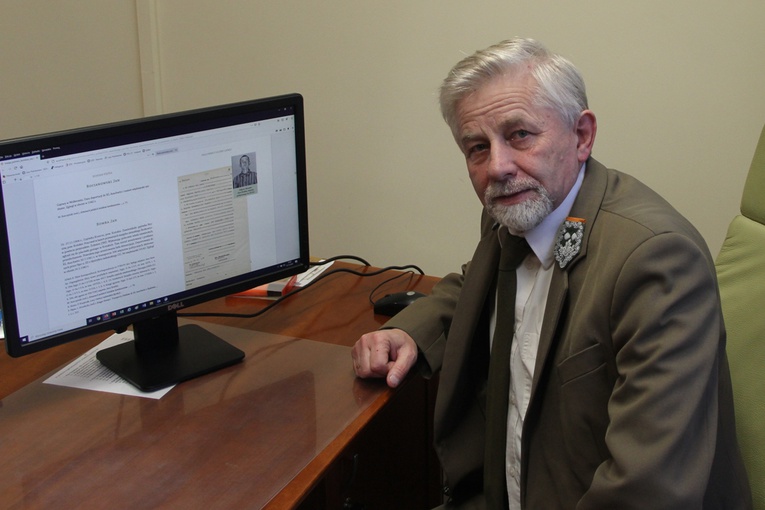 Piotr Kacprzak pokazuje na monitorze jedną ze stron publikacji, która jest dostępna w Internecie.