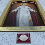 Papieska piuska pod obrazem św. Jana Pawła II w prezbiterium.