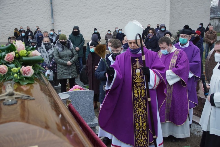 Biskup wraz ze zgromadzonymi nad grobem żałobnikami.