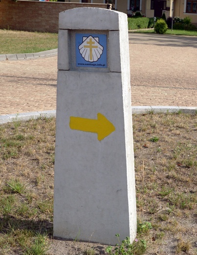 Przy kościele w Skaryszewie stoi betonowy słupek z symbolem szlaku.