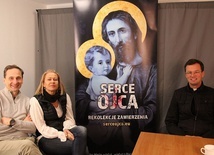 Od lewej: Marek i Adriana Zarembowie oraz ks. Mateusz Dudkiewicz przy rekolekcyjnym banerze, zapraszjącym na 27 dni z Sercem Ojca.