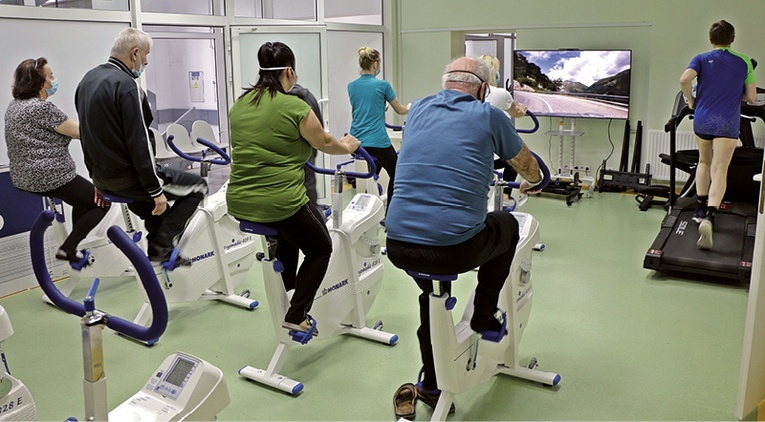 Rehabilitacja pocovidova w Głuchołazach. Wśród aktywności jest jazda na rowerze przy obserwowaniu dynamicznie zmieniających się krajobrazów na ekranie telewizora.