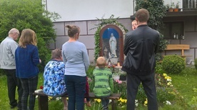 Rodzina pana Józefa i Joanny przed domową kapliczką w Piekiełku.
