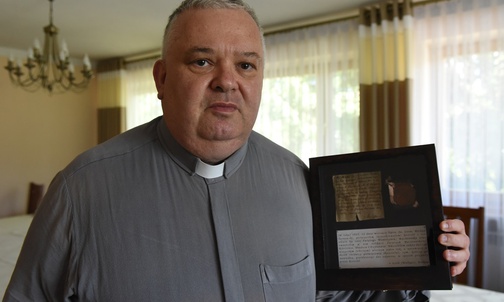Ks. proboszcz Piotr Lisowski prezentuje list arcybiskupa Wałęgi sprzed 100 lat.