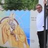 Ks. Maciej Jastrzębski, proboszcz parafii św. Stanisława BM przy muralu z Prymasem Tysiąclecia.