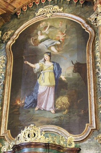 ▲	Obraz zawieszony w ołtarzu głównym kościoła pw. św. Tekli w Pławnej.