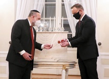 Naczelny rabin Polski Michael Schudrich  i prezydent Andrzej Duda zapalają światełka chanukowe.
