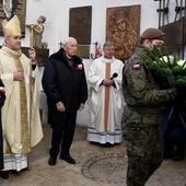 Po Mszy św. biskup wraz z (od lewej): prof. Jerzym Grzywaczem oraz kmdr. Romanem Rakowskim złożyli kwiaty przy nowo odsłoniętej i poświęconej tablicy ku czci poległych i zmarłych żołnierzy wszystkich formacji Armii Krajowej.