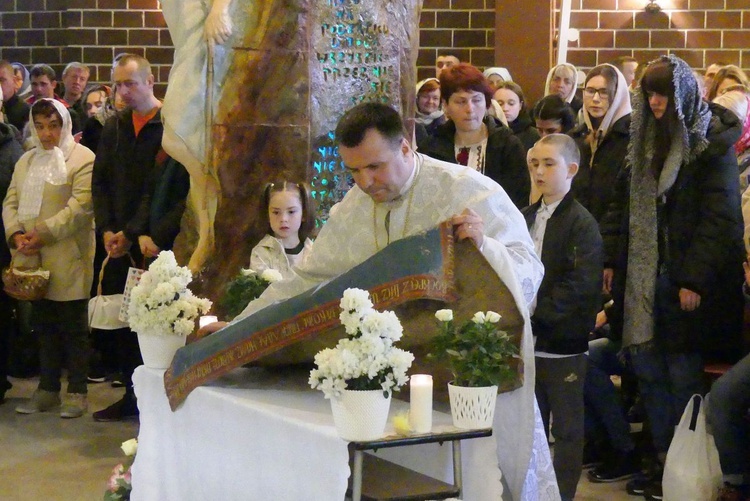 Ks. Mikołaj Preszlak przenosi płaszczenicę z wizerunkiem Jezusa złożonego w grobie na ołtarz.