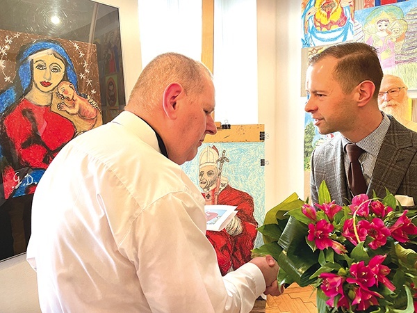 Grzegorz Dostatni odbiera kwiaty przy swoim najnowszym dziele.