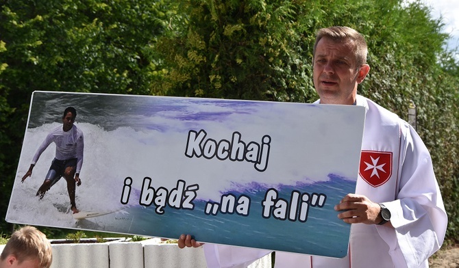 Ks. Marcin Zawada z banerem zachęcającym do naśladowania kandydata na ołtarze.