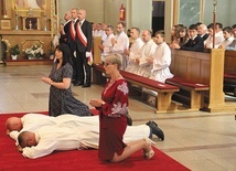 Święcenia diakonatu Bartosza Kaczmarczyka i Krzysztofa Kurpanika w kościele św. Andrzeja Boboli w Leszczynach, w archidiecezji katowickiej. Obok przyjmujących święcenia klęczą ich żony.