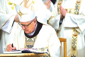 Biskup Edward Dajczak podpisuje uchwały synodalne podczas  Mszy św. kończącej synod.