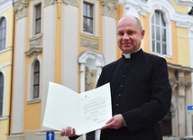 Ksiądz Stanisław Brasse pokazuje dekret Stolicy Apostolskiej.