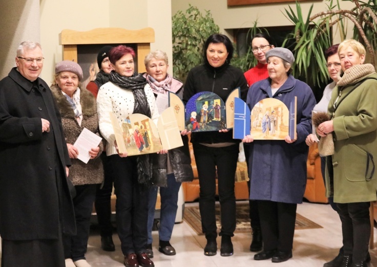 Grupa pań odbiera przygotowane przez ks. kan. Ignacego Czadera tryptyki z obrazem Świętej Rodziny.