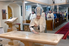 Biskup namaszczający ołtarz w czasie obrzędu poświęcenia.