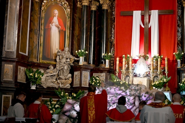 Biskup okadzający grób Pański. Obok wizerunek św. Jana Pawła II.
