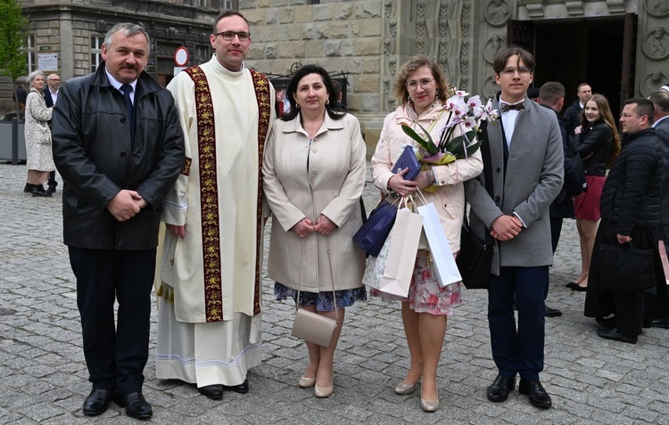 Czas na życzenia przed katedrą - diakon Piotr Kania z rodzicami i rodzeństwem.