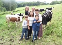 Rodzina Michurów, a za nimi krowy.