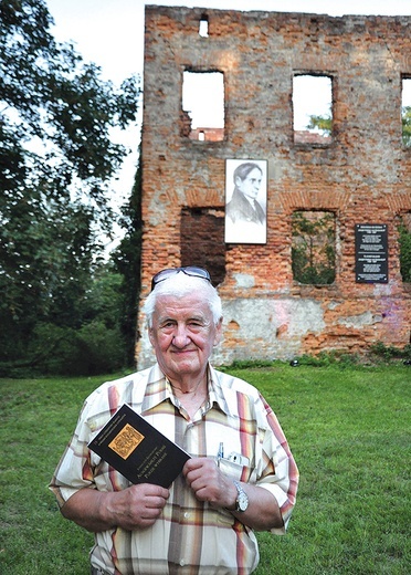 Autor ze swoim tomikiem w Łubowicach, na tle ruin pałacu rodzinnego poety.