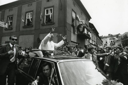 Samochód z Janem Pawłem II wjeżdża na wadowicki rynek, za plecami Ojca Świętego widać jego rodzinny dom.  Wadowice, 7 VI 1979 r. 