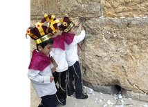 Żydowscy chłopcy zbierają tysiące karteczek z modlitwami wetkniętych w ścianę