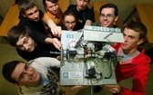 Młodzi robotycy ze swoim robotem układającym kostkę Rubika.