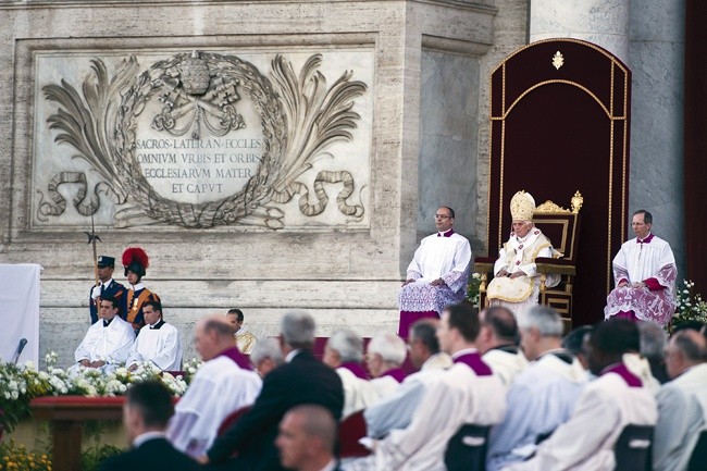 7.06. br., Boże Ciało. Benedykt XVI celebruje Mszę św. obok inskrypcji głoszącej, że bazylika jest  „Matką i Głową kościołów Miasta i świata” 